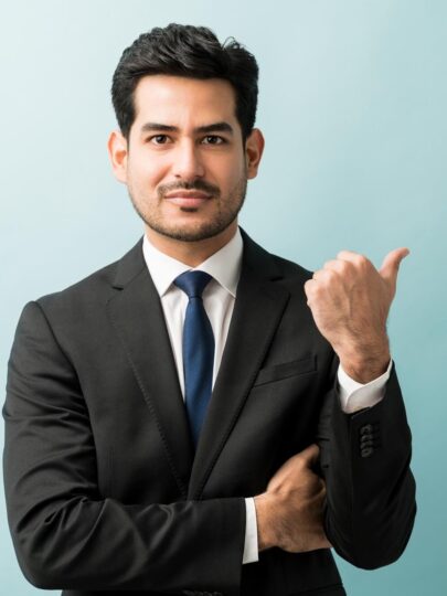 hispanic-male-executive-gesturing-copy-space-while-making-eye-contact-studio